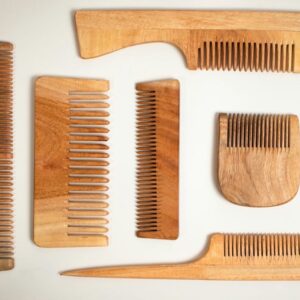Wooden hair combs of different tooth widths laid out on a white surface