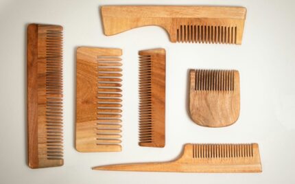 Wooden hair combs of different tooth widths laid out on a white surface