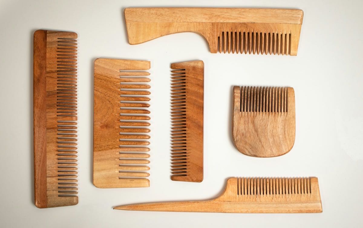 Wooden hair combs of different tooth widths laid out on a white surface