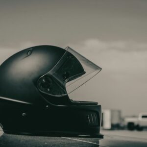 Matte black motorcycle helmet resting on a flat surface against a soft neutral background