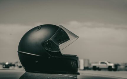 Matte black motorcycle helmet resting on a flat surface against a soft neutral background