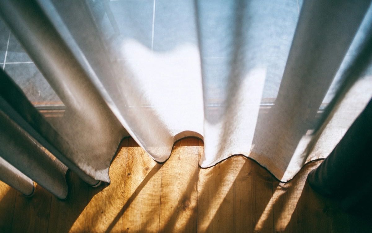 Sheer curtain moving in warm afternoon light