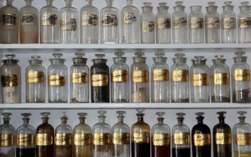 Shelves of apothecary jars with gold ingredient labels