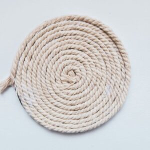 Cream-coloured rope coiled into a spiral on a white surface