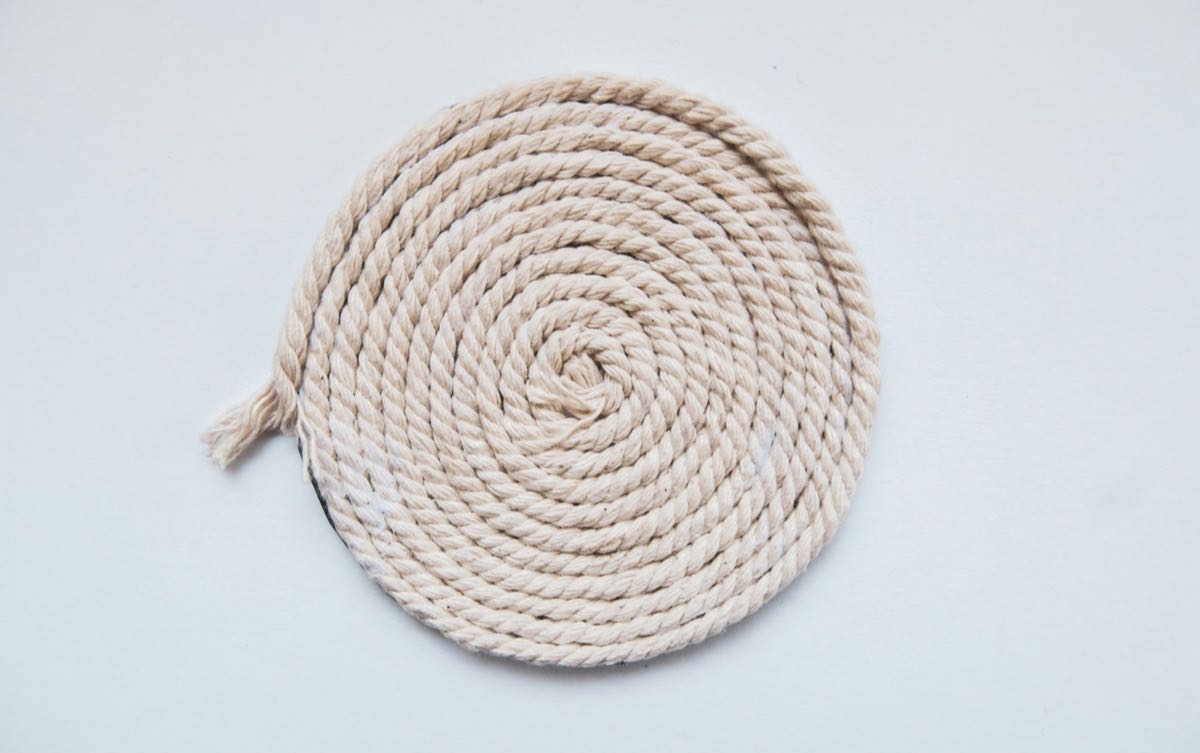 Cream-coloured rope coiled into a spiral on a white surface