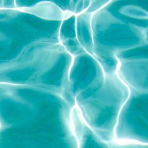 Sunlight rippling across the surface of turquoise pool water