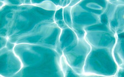 Sunlight rippling across the surface of turquoise pool water