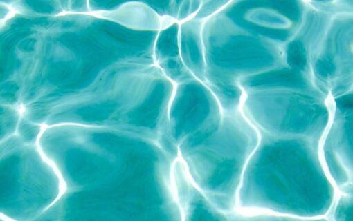 Sunlight rippling across the surface of turquoise pool water