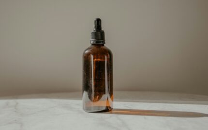 Amber glass dropper bottle of hair treatment oil in soft light