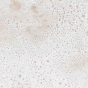 Close-up of soft cream-coloured shampoo lather and fine bubbles