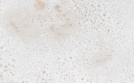 Close-up of soft cream-coloured shampoo lather and fine bubbles